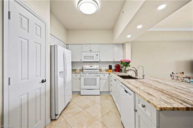 a kitchen with white cabinets and white appliances