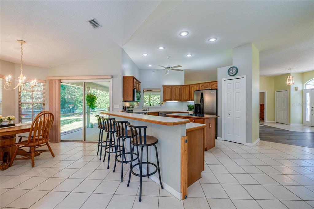 27 Foxhunter Flat Ormond Beach, FL 32174 - Photo 14 of 47 a kitchen with stainless steel appliances granite countertop a table chairs and a refrigerator
