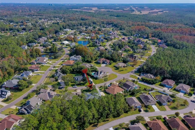 an aerial view of residential houses with outdoor space and trees