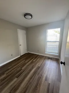 a view of a room with wooden floor and window