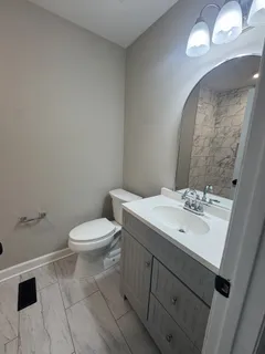 a bathroom with a toilet a sink and mirror