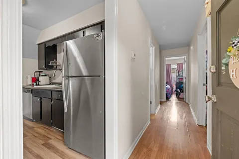 a view of a hallway with wooden floor and closet