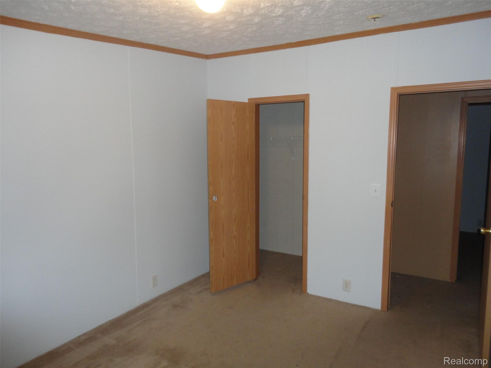 3954 Ryans Ridge Monroe, MI 48161 - Photo 18 of 28 Bedroom 2 featuring white walls, light wood trim, and a ceiling-mounted light fixture