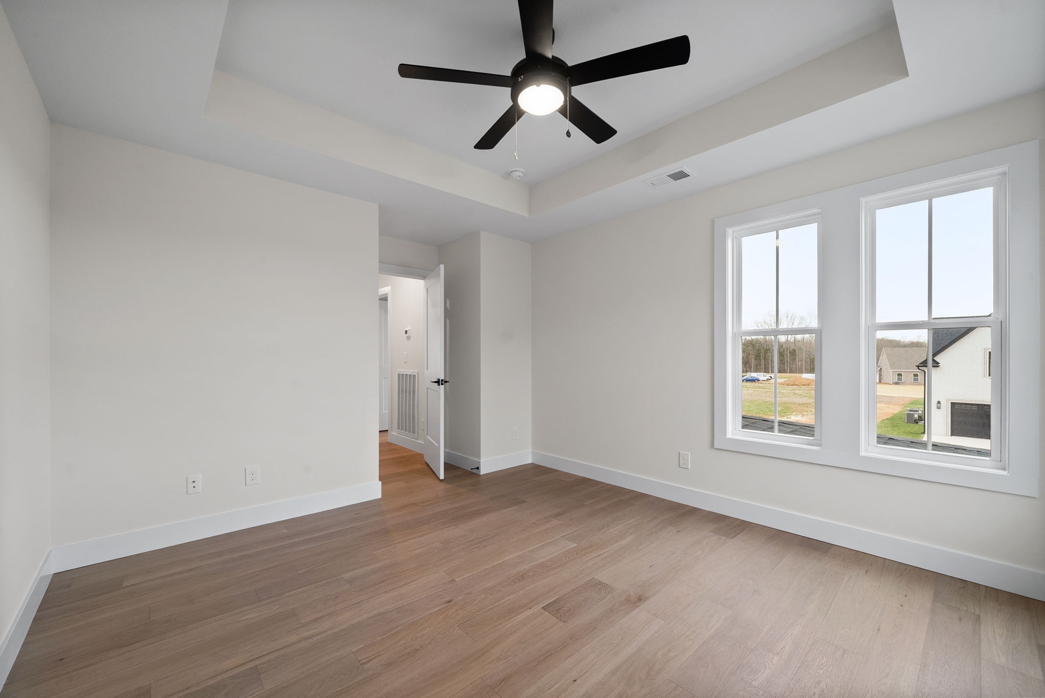 15 Rustling Oaks Court Pleasant View, TN 37146 - Photo 40 of 50 an empty room with wooden floor ceiling fan and windows