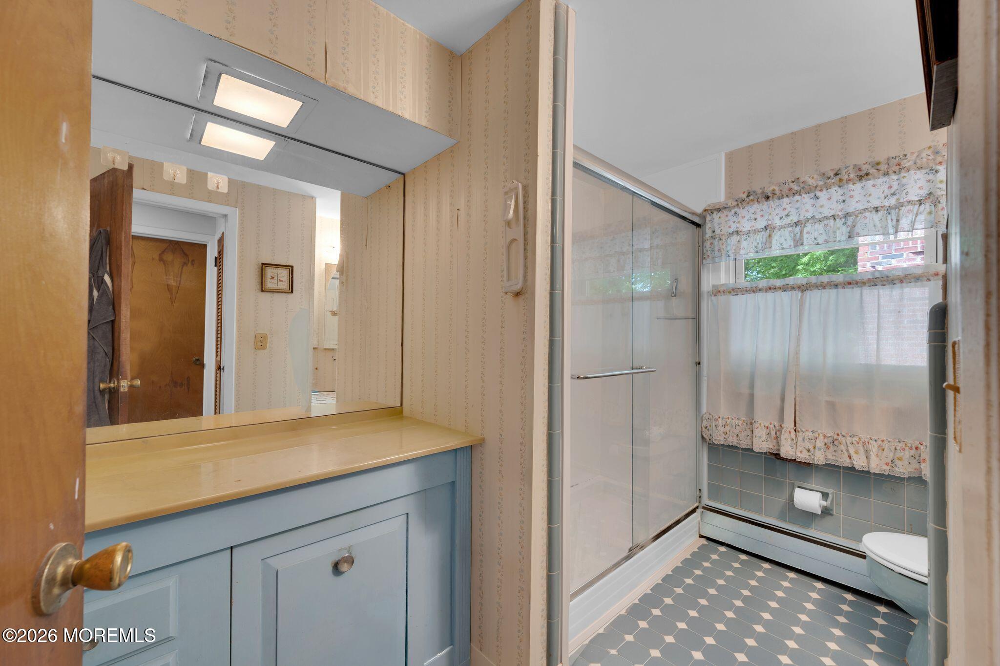 2604 Logan Road Asbury Park, NJ 07712 - Photo 20 of 39 a bathroom with a shower sink and mirror