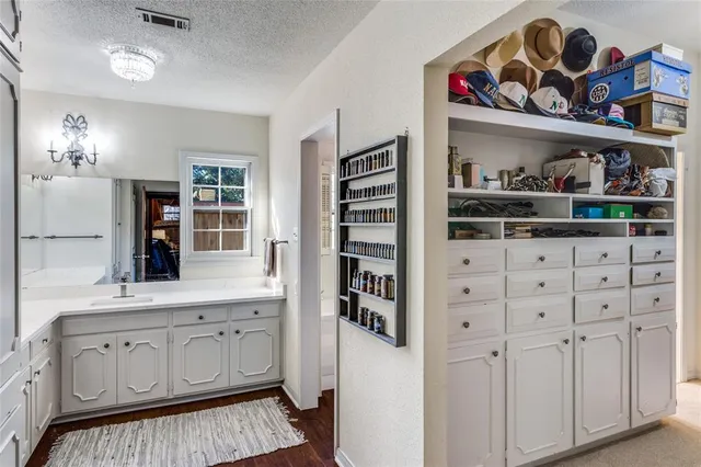 a kitchen with white cabinets and wooden floor