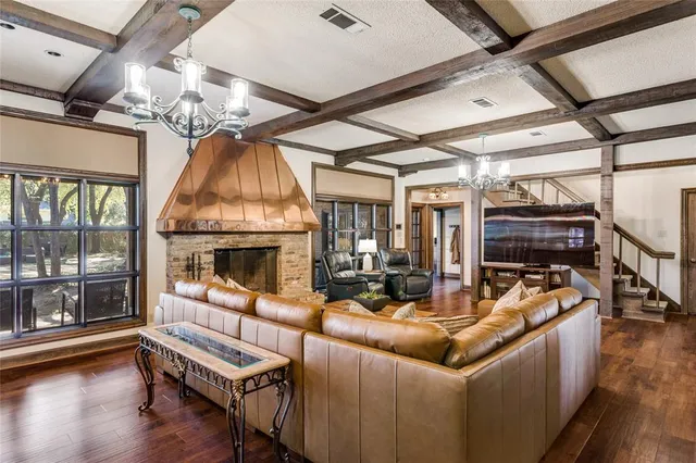 a living room with furniture a fireplace and a chandelier