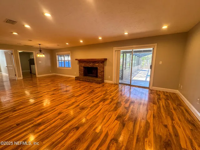 a view of an empty room with a fireplace and a window