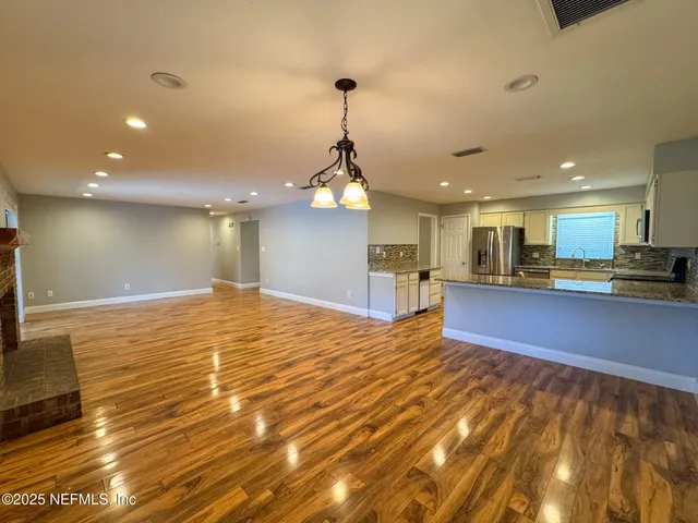 a kitchen with stainless steel appliances granite countertop a sink refrigerator and microwave