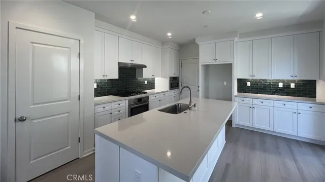 a kitchen with a sink a microwave a refrigerator and cabinets