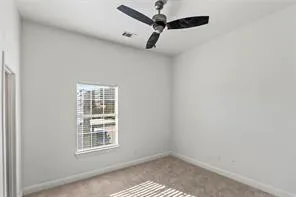 an empty room with a window and a ceiling fan