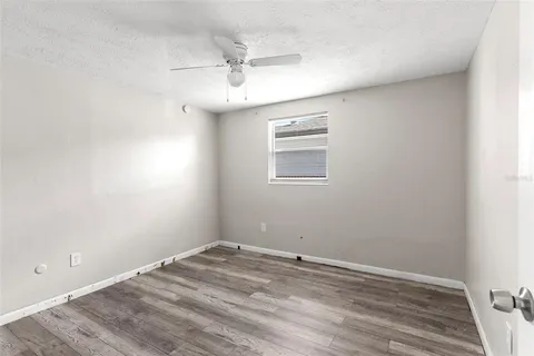an empty room with a window and ceiling fan