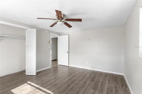 a view of a room with wooden floor and ceiling fan