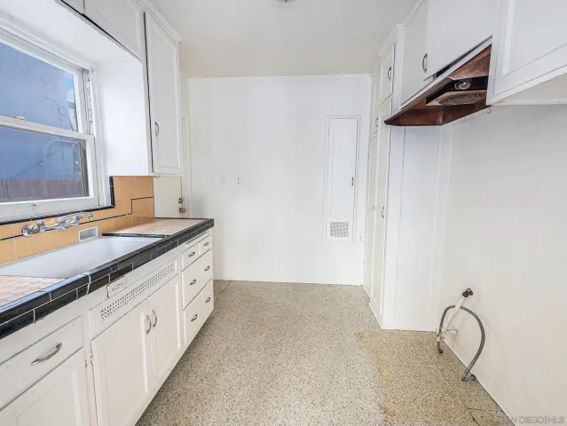 a spacious bathroom with a granite countertop sink and a mirror