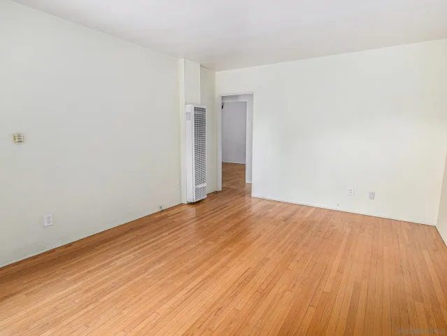 a view of an empty room with wooden floor