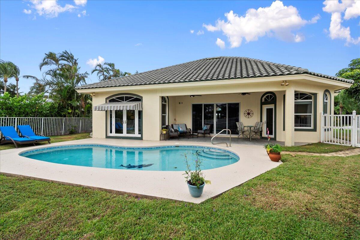 a view of a house with a swimming pool with a yard and plants