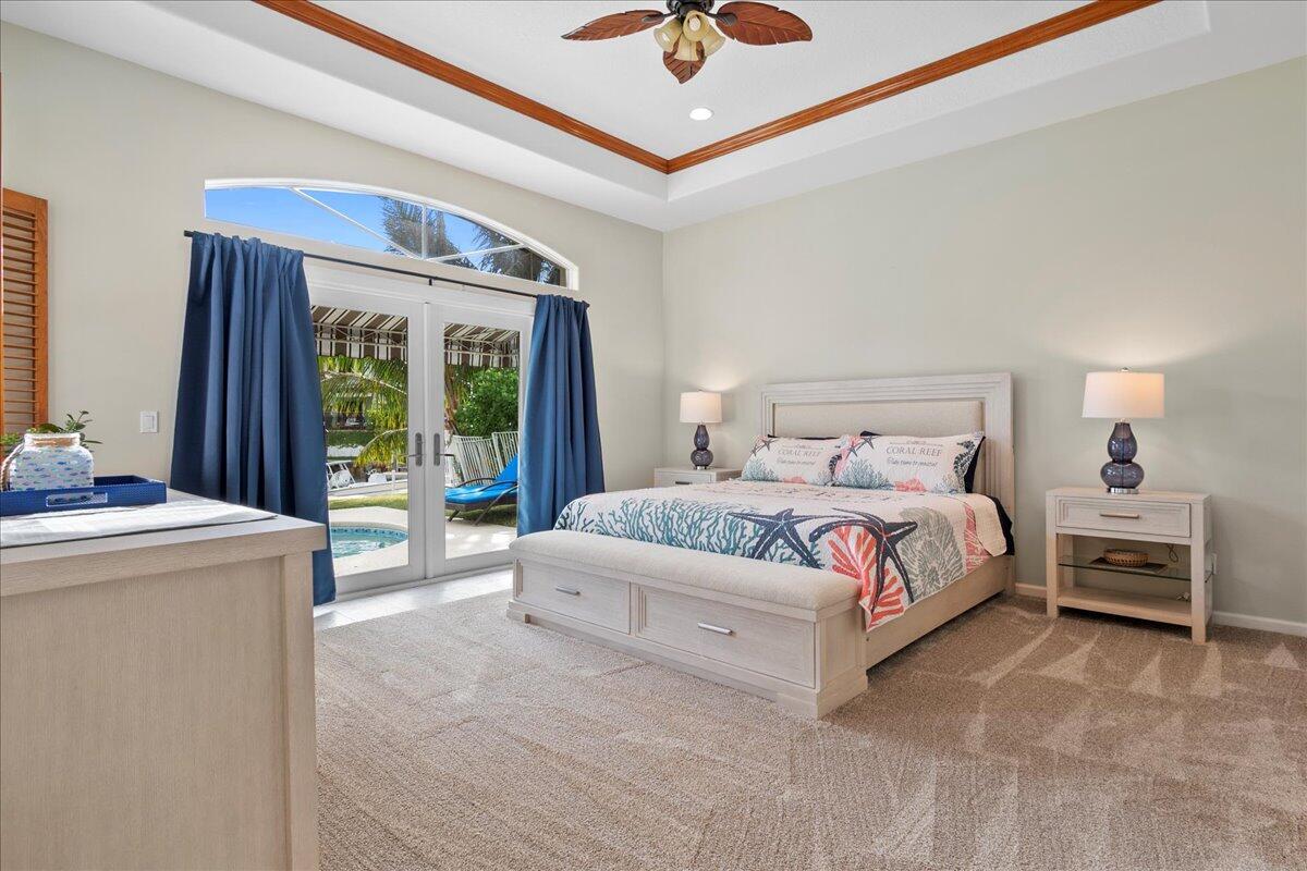 72 Waterway Road Jupiter, FL 33469 - Photo 16 of 57 a bedroom with a bed and a chandelier