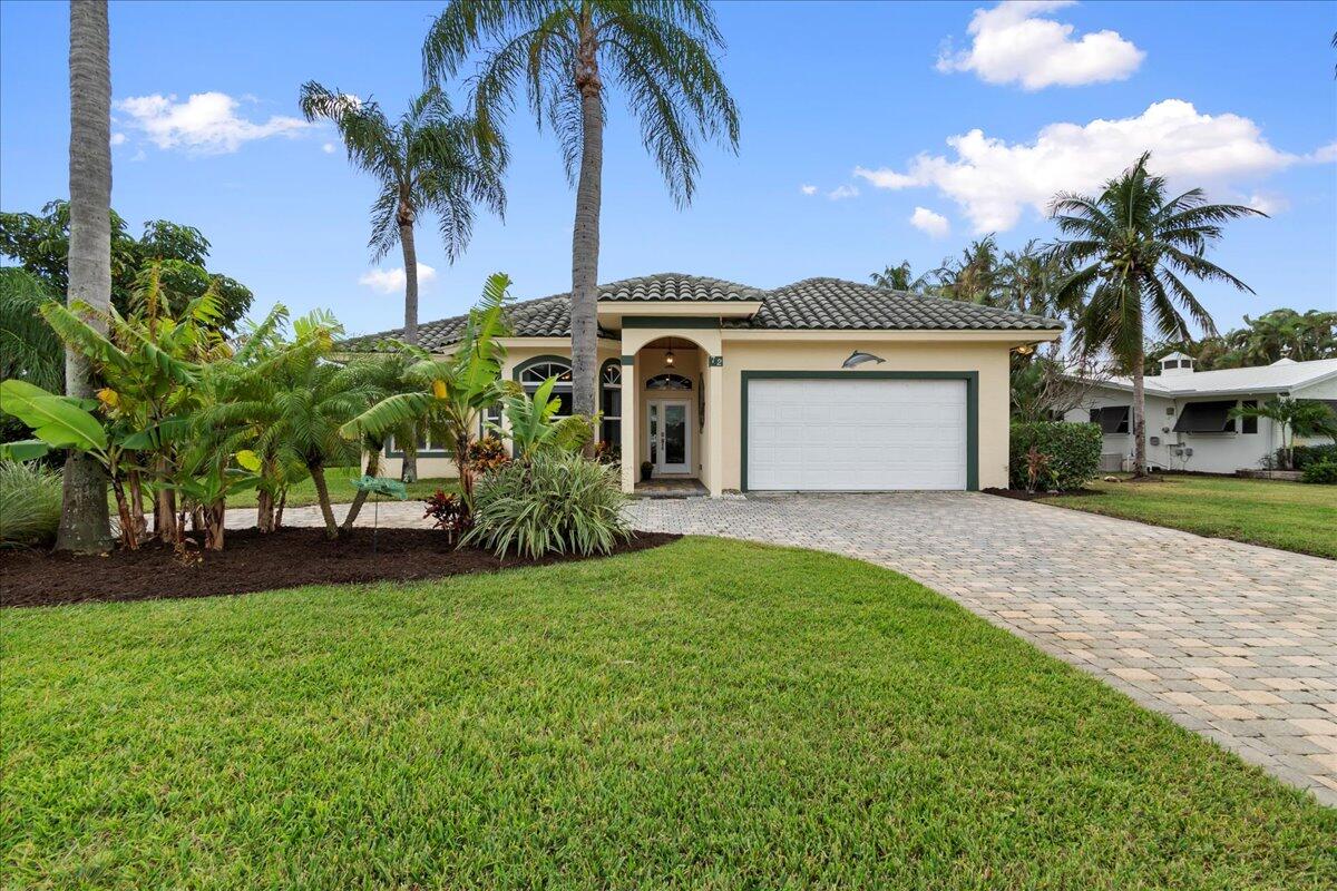 72 Waterway Road Jupiter, FL 33469 - Photo 2 of 57 a front view of a house with a garden and yard