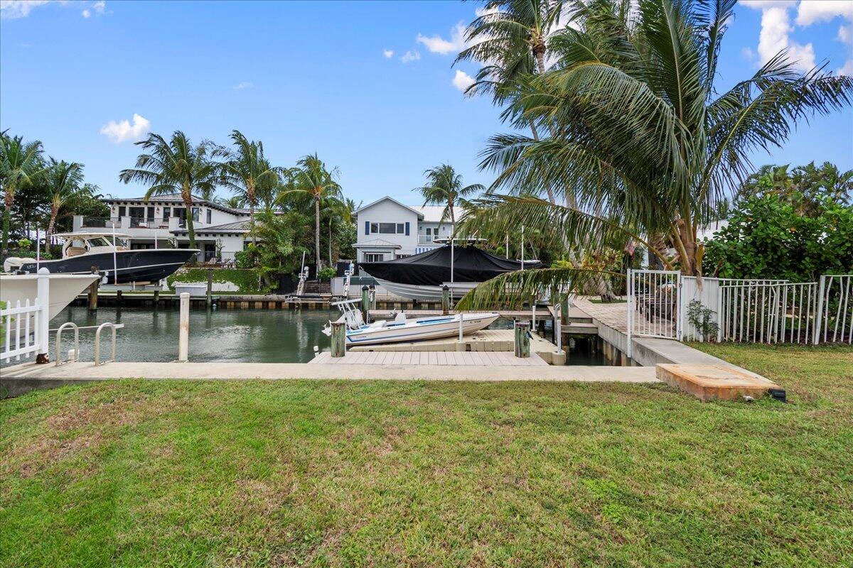 72 Waterway Road Jupiter, FL 33469 - Photo 34 of 57 a view of a swimming pool with a bench and trees
