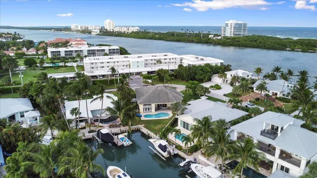 an aerial view of a city with lots of residential buildings ocean and mountain view in back