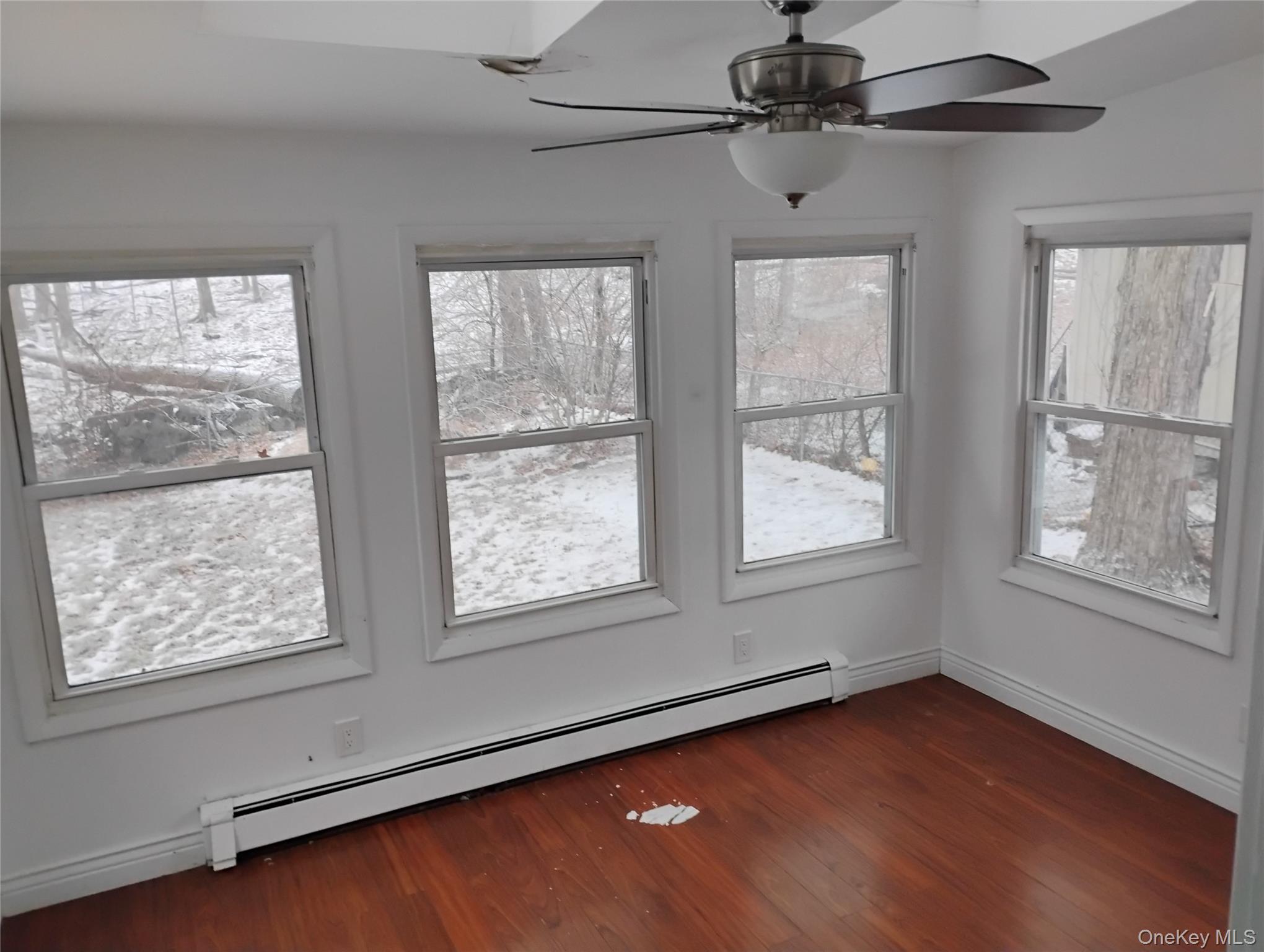 9 Merriewold Lane South Monroe, NY 10950 - Photo 13 of 14 Unfurnished dining area featuring a baseboard radiator, dark wood finished floors, and ceiling fan
