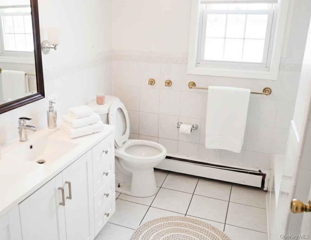 9 Merriewold Lane South Monroe, NY 10950 - Photo 3 of 14 Bathroom featuring a baseboard heating unit, vanity, light tile patterned floors, plenty of natural light, and tile walls