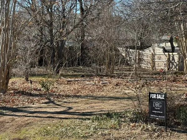 a view of a yard with wooden fence