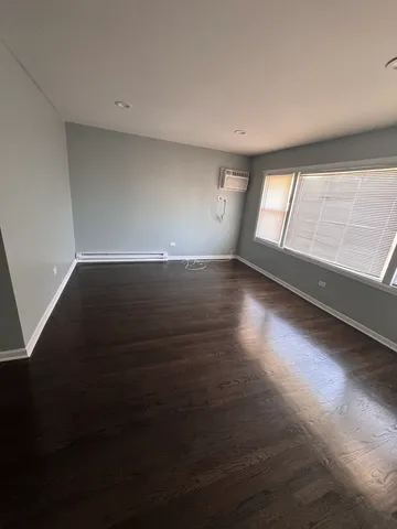an empty room with wooden floor and windows in it