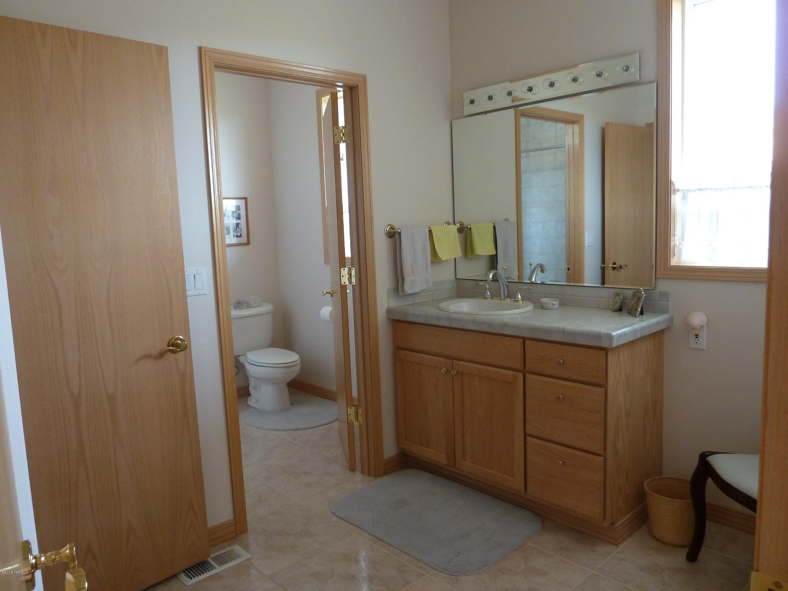 14000 Marble Road Yakima, WA 98908 - Photo 14 of 22 a bathroom with a granite countertop sink a toilet and a mirror