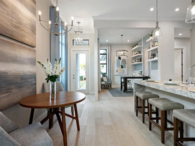 a kitchen with stainless steel appliances kitchen island a table and chairs in it