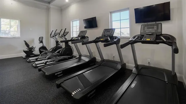 a room with gym equipment and a flat screen tv