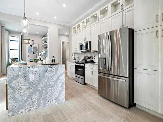 a kitchen with granite countertop a refrigerator and a sink