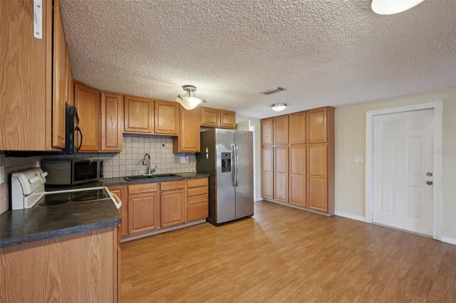 a kitchen with stainless steel appliances granite countertop a refrigerator sink and cabinets