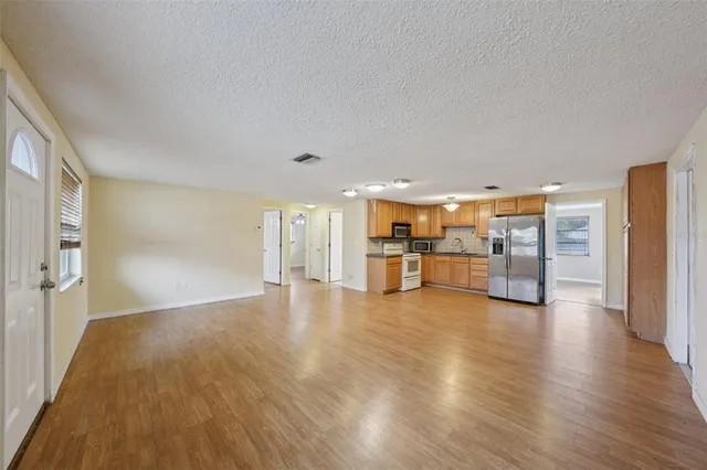 a view of empty room with wooden floor