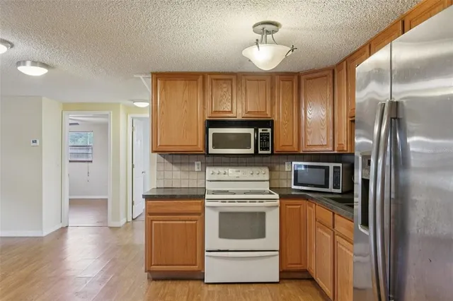 a kitchen with a refrigerator stove and microwave