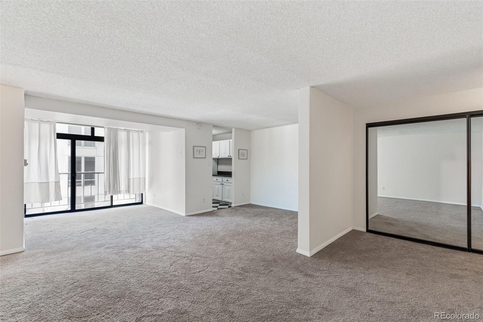 2 Adams Street, Unit 910 Denver, CO 80206 - Photo 3 of 15 an empty room with closet and mirror