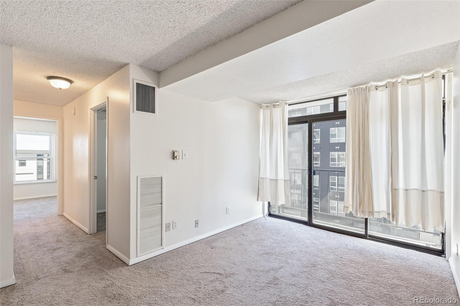 2 Adams Street, Unit 910 Denver, CO 80206 - Photo 4 of 15 an empty room with windows and closet