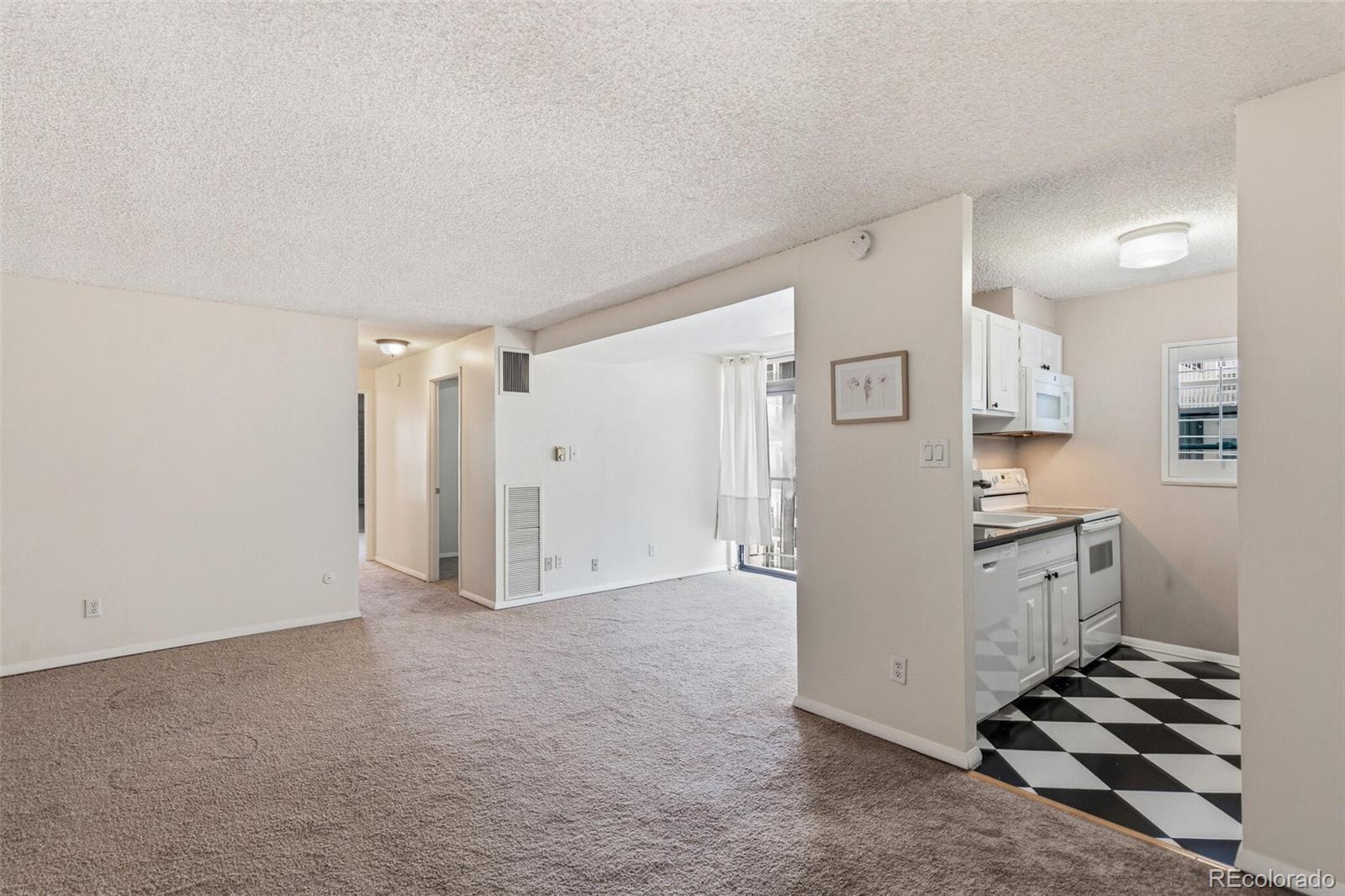 2 Adams Street, Unit 910 Denver, CO 80206 - Photo 6 of 15 a view of a kitchen with refrigerator stove and cabinets