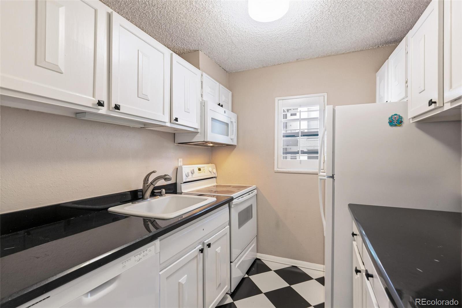 2 Adams Street, Unit 910 Denver, CO 80206 - Photo 8 of 15 a kitchen with stainless steel appliances a sink stove and cabinets