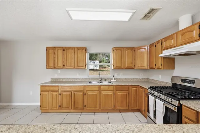 a kitchen with a sink stove and cabinets
