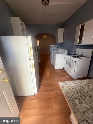 a kitchen with a sink a stove top oven and cabinetry