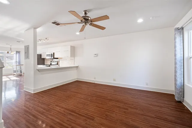 a view of a kitchen with wooden floor and electronic appliances