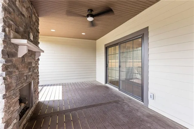 a view of an empty room with wooden floor and a fireplace