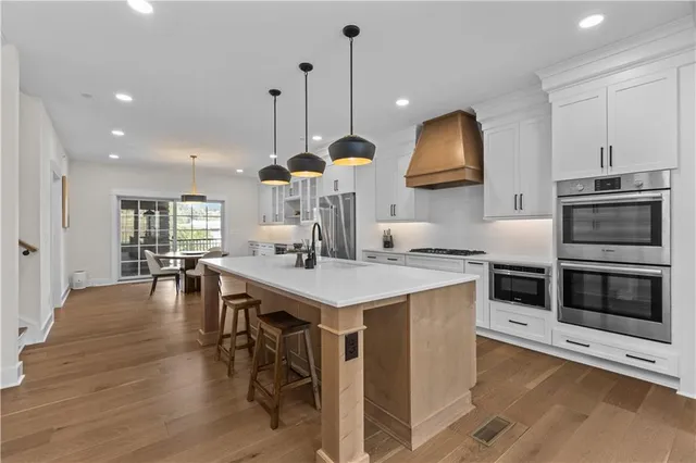 a kitchen with kitchen island a stove and a wooden floor