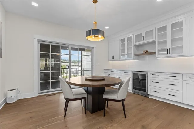 a dining room with furniture a chandelier and wooden floor