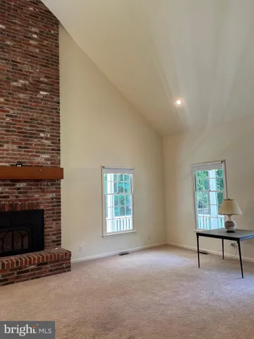 a view of an empty room with a fireplace and a window