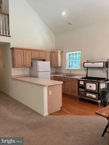a kitchen with a refrigerator and a stove top oven