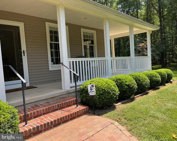 a view of a house with a small yard and flower plants
