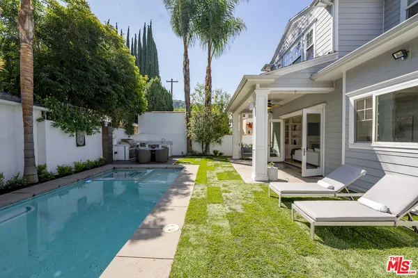 a view of a house with a swimming pool and sitting area