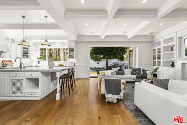 a kitchen with stainless steel appliances granite countertop a white cabinets and wooden floor